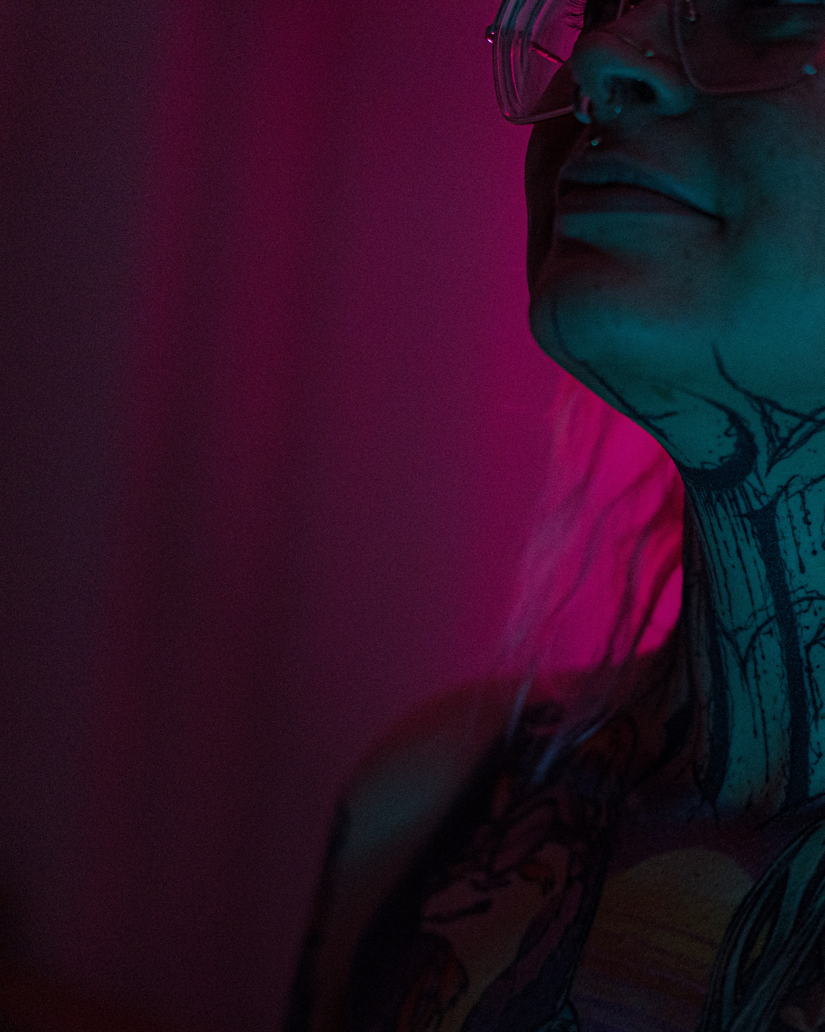 Muse reference photograph by Samma Charles — close-up profile portrait under magenta and teal light, neck tattoo visible